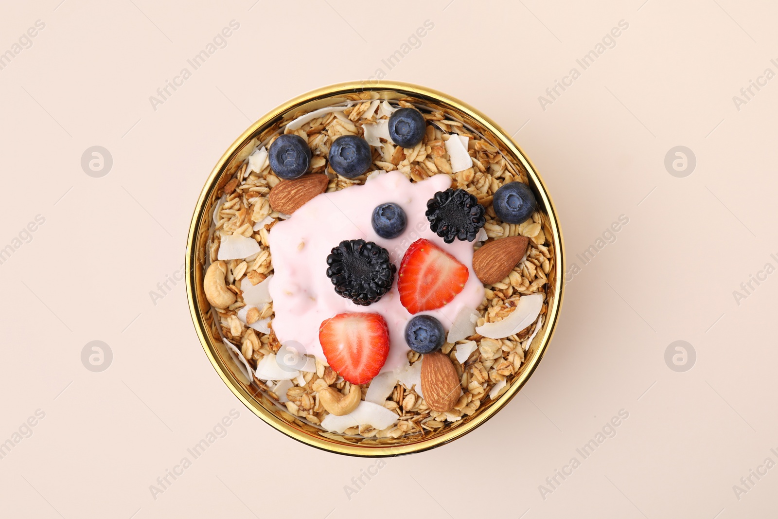 Photo of Tasty granola, yogurt and fresh berries in bowl on beige background, top view. Healthy breakfast