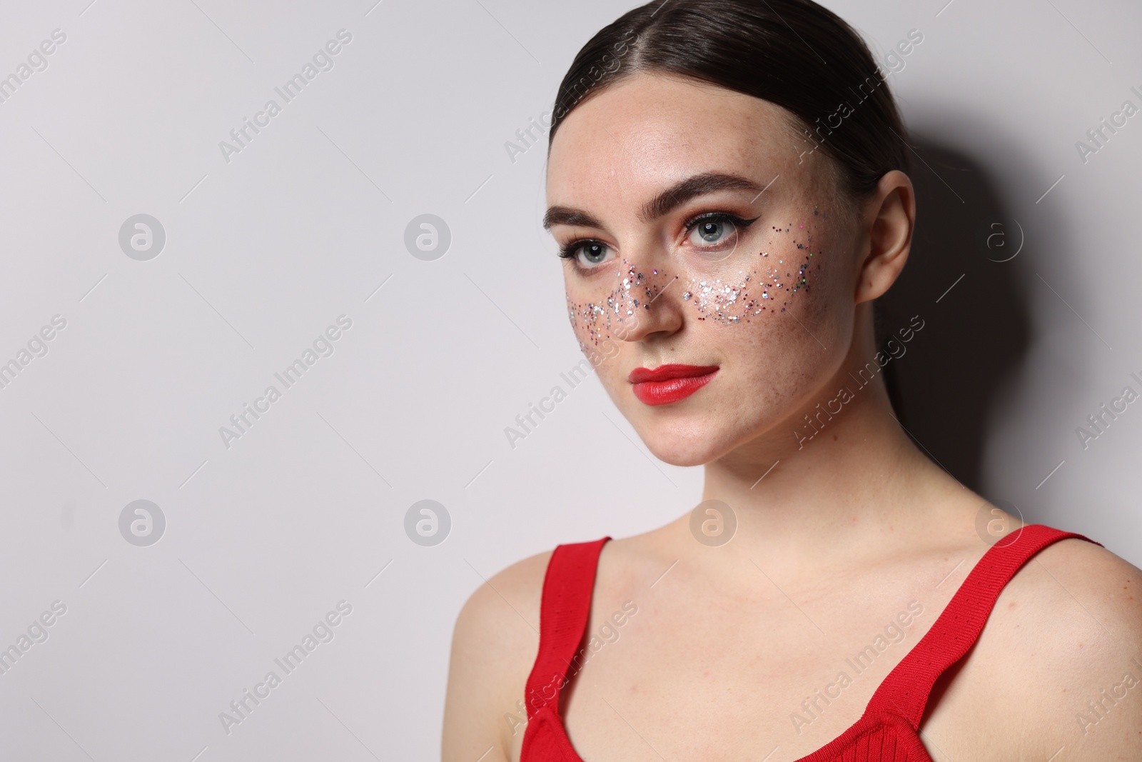 Photo of Beautiful woman with glitter freckles on light background. Space for text