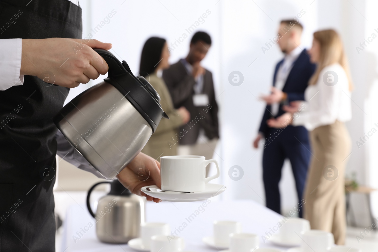 Photo of Waitress pouring hot drink during coffee break, closeup