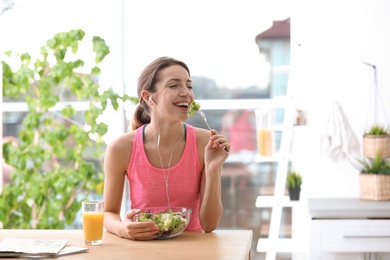 Young woman in fitness clothes having healthy breakfast at home