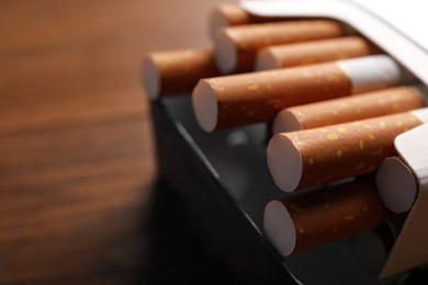 Pack of cigarettes on blurred background, closeup. Space for text