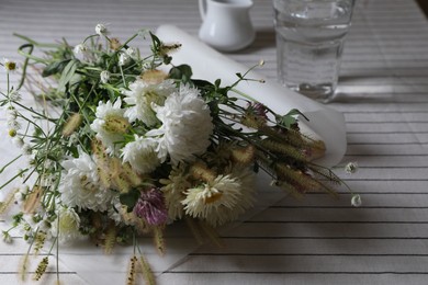 Bouquet of beautiful wild flowers and spikelets on table