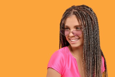 Photo of Beautiful woman with long african braids on yellow background, space for text