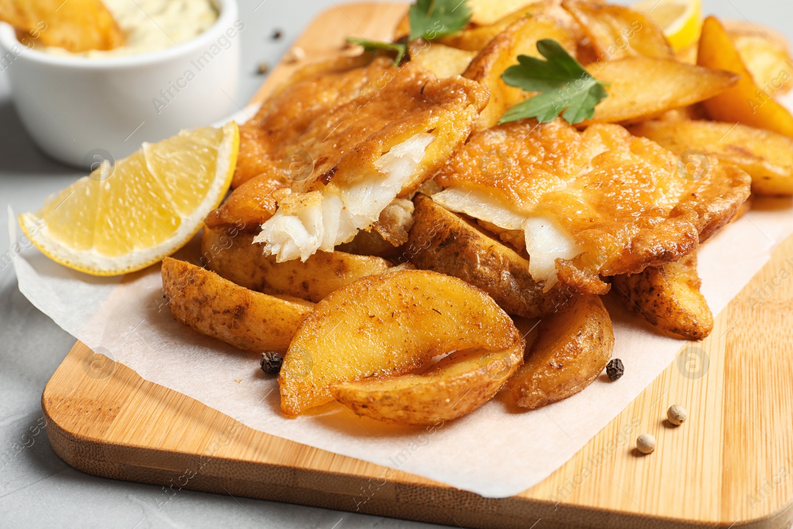 Photo of British traditional fish and potato chips on table, closeup