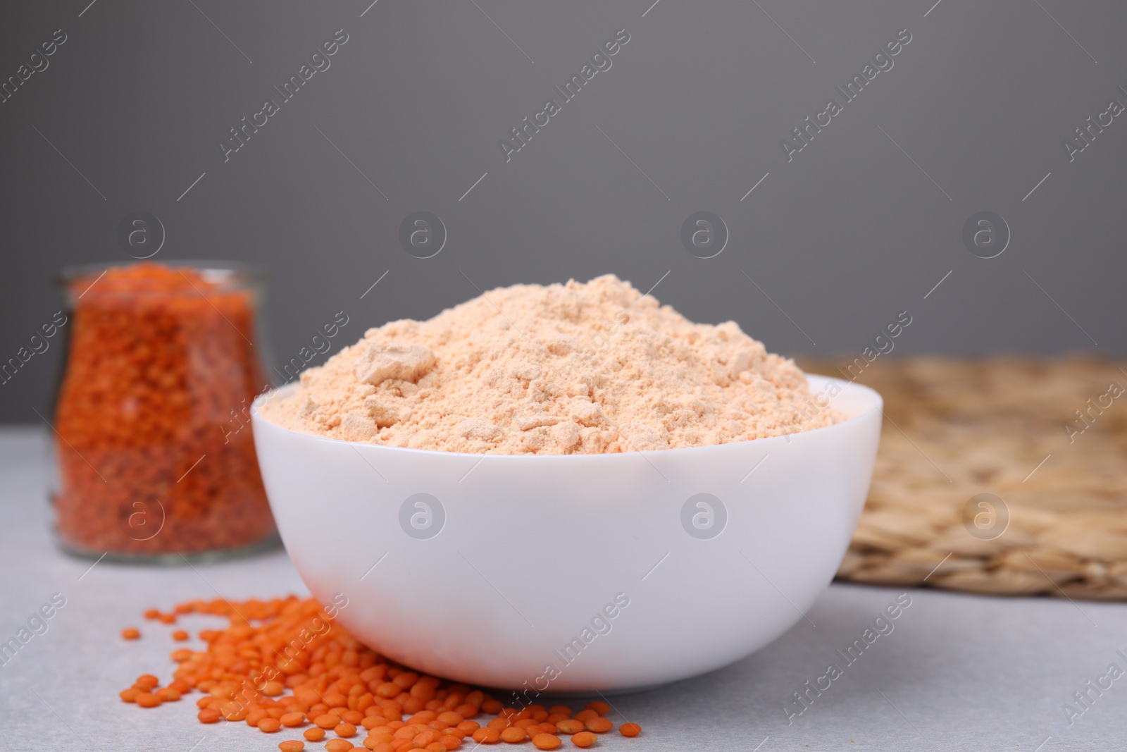 Photo of Lentil flour and seeds on white table, closeup