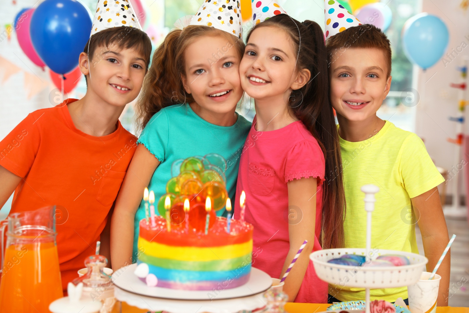 Photo of Happy children near cake with candles at birthday party indoors