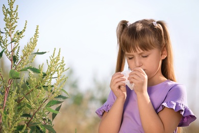 Photo of Little girl suffering from ragweed allergy outdoors