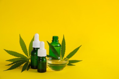 Photo of Hemp leaves, CBD oil and THC tincture on yellow background. Space for text