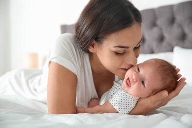 Young woman with her newborn baby on bed