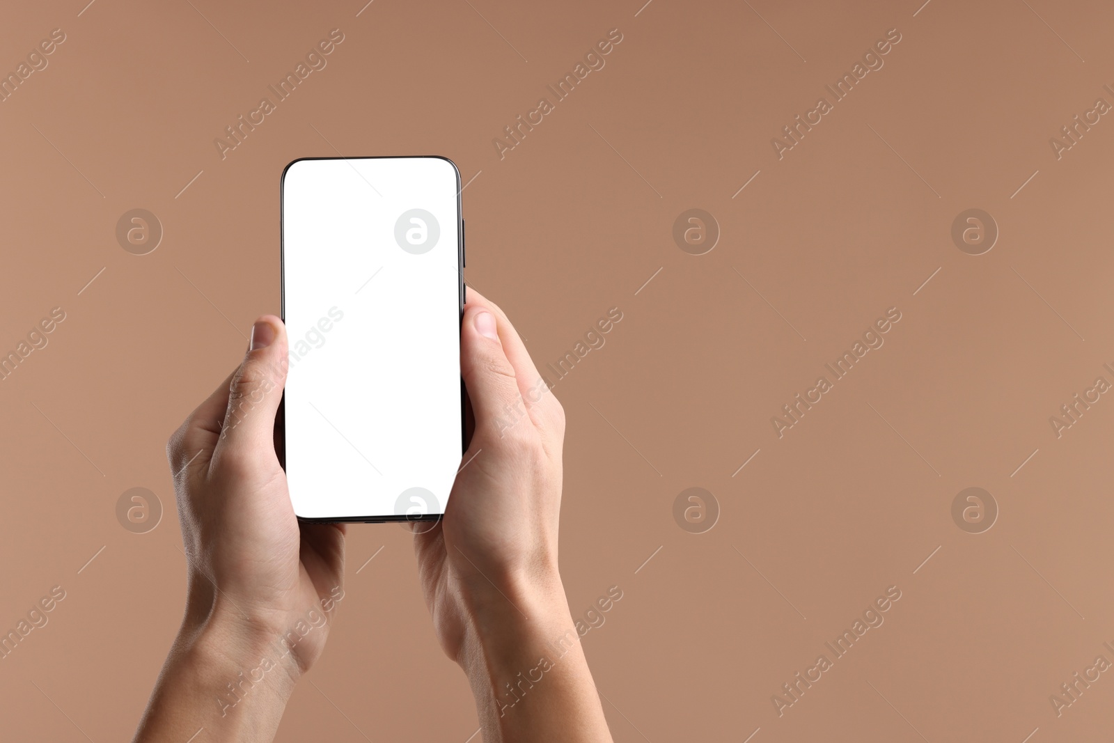 Photo of Man holding smartphone with blank screen on beige background, closeup. Mockup for design