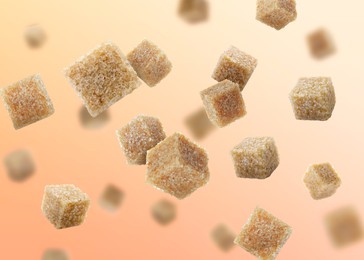 Image of Brown cane sugar cubes falling on peach color gradient background