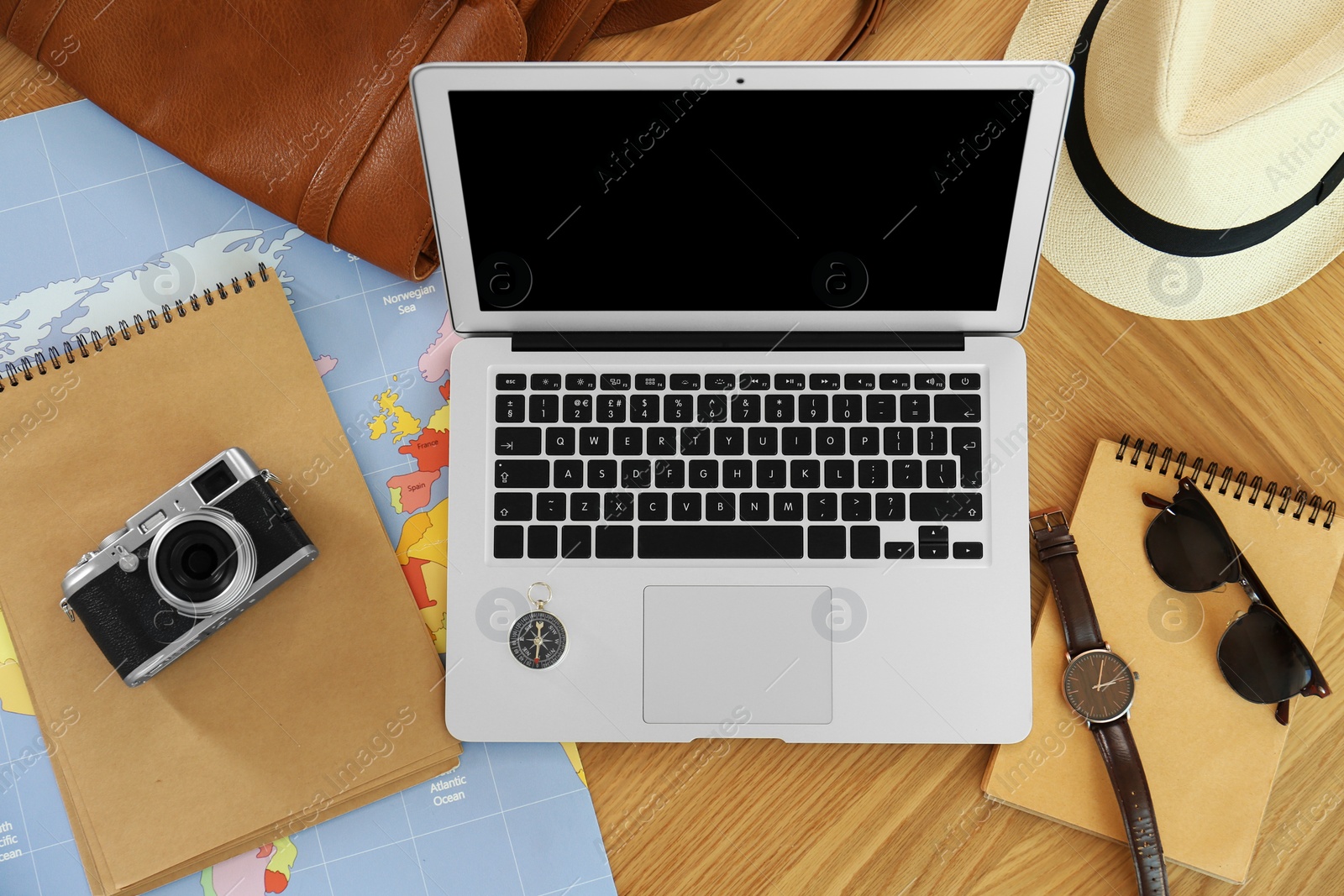 Photo of Flat lay composition with laptop and different items on wooden table. Trip planning