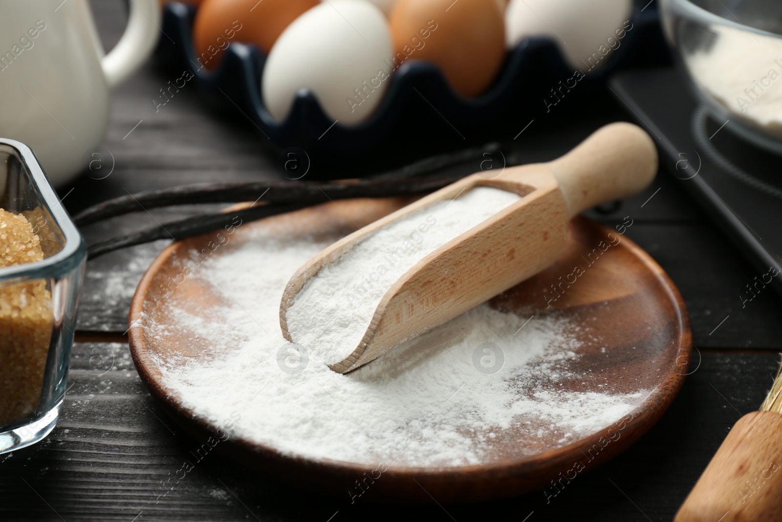 Photo of Pate and scoop with baking powder on black wooden table, closeup