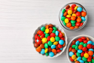 Photo of Tasty colorful candies on white wooden table, flat lay. Space for text