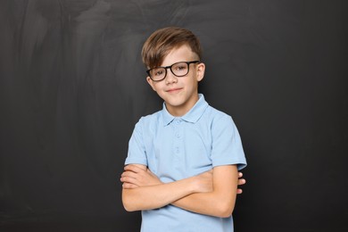 Photo of Back to school. Cute boy in glasses near chalkboard