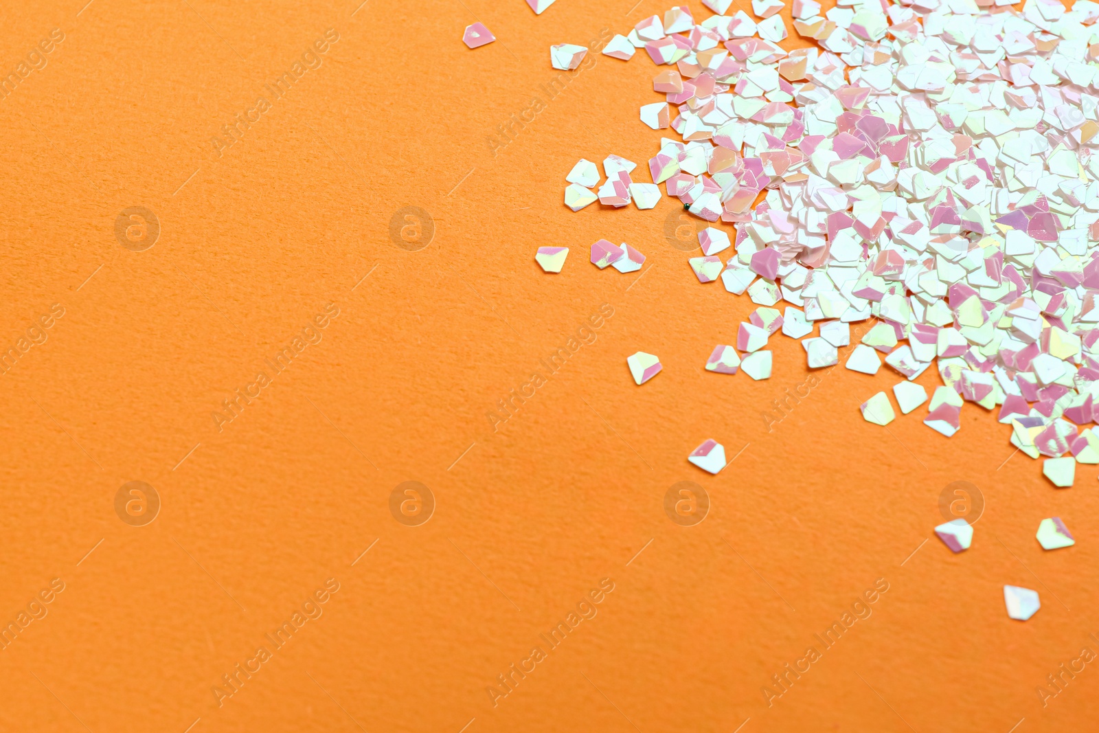 Photo of Shiny bright glitter on yellow background. Space for text