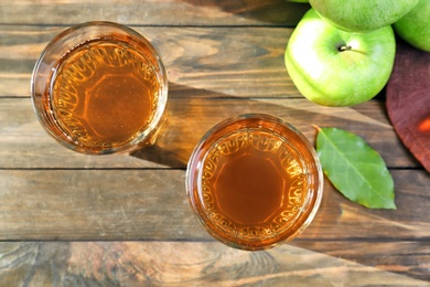 Two glasses of fresh apple juice on wooden table, top view