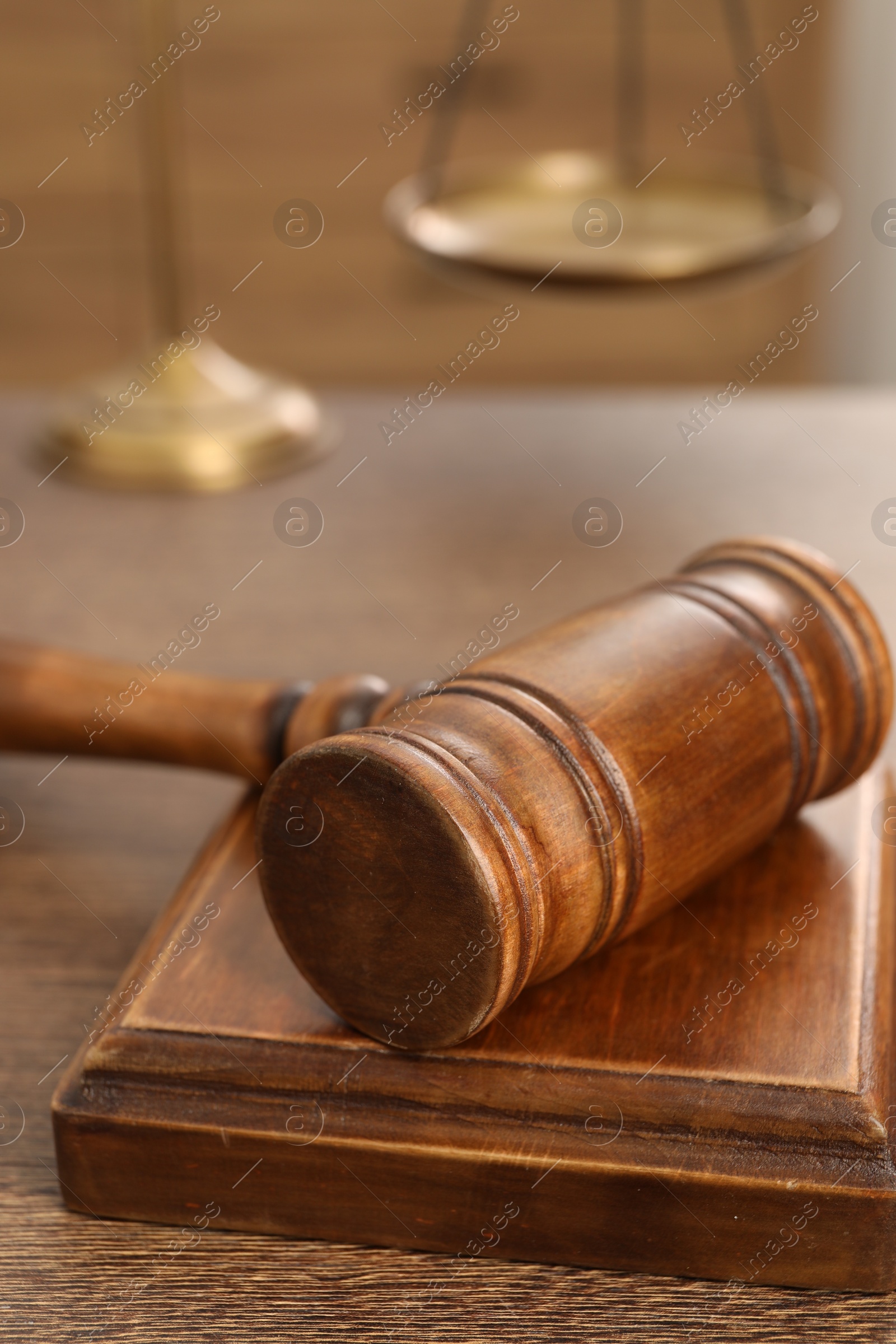 Photo of Wooden gavel and sound block on table indoors, closeup