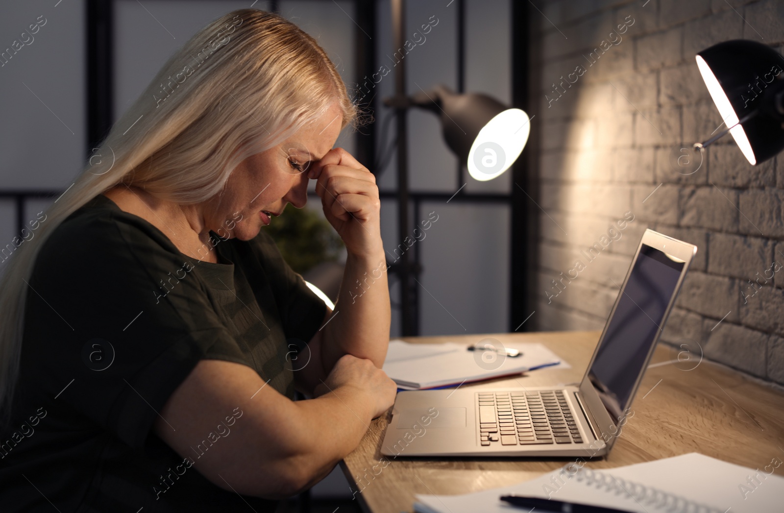 Photo of Overworked mature woman with headache in office