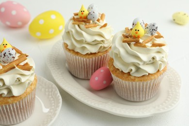 Tasty Easter cupcakes with vanilla cream on white table, closeup