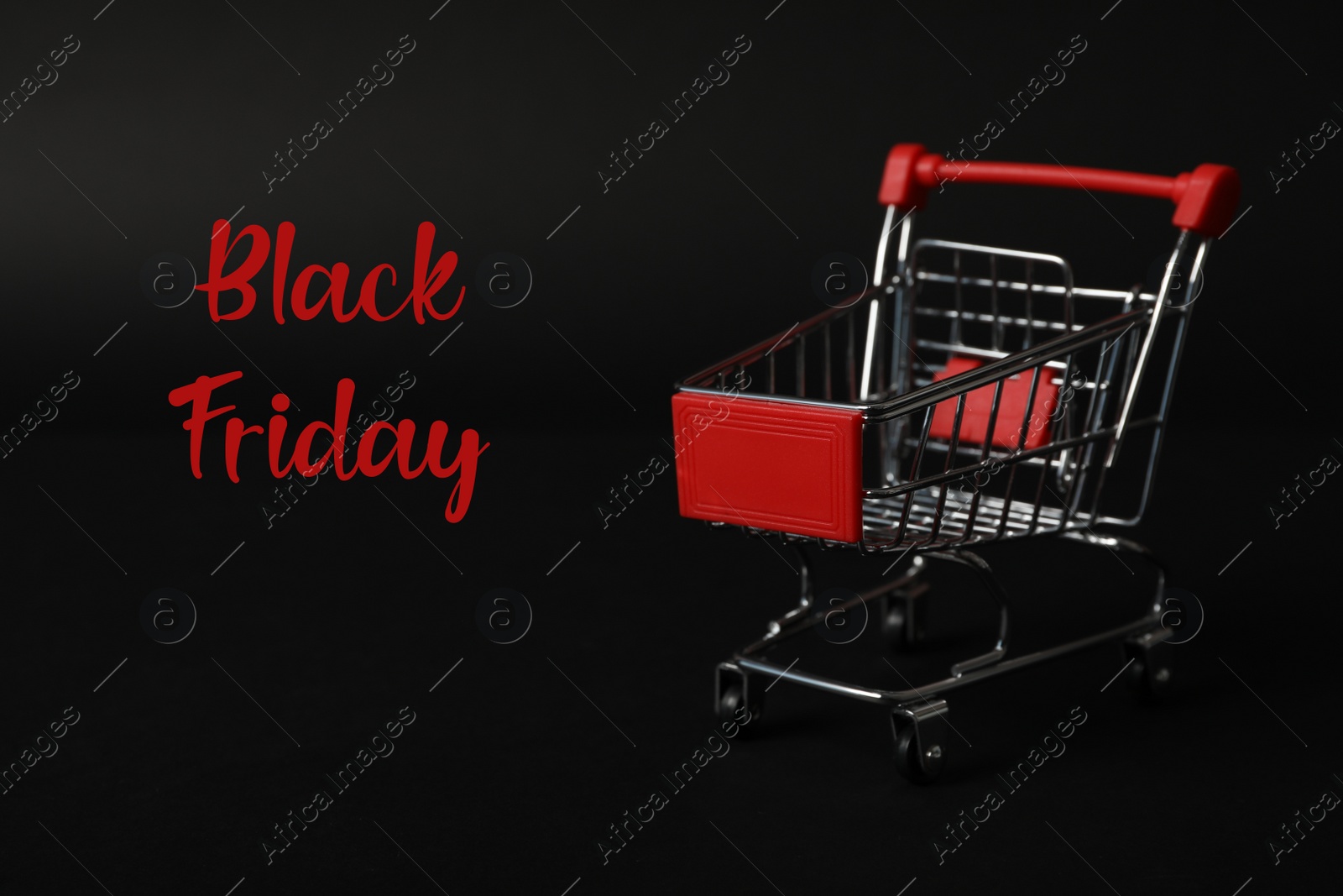 Photo of Phrase Black Friday and toy shopping cart on dark background