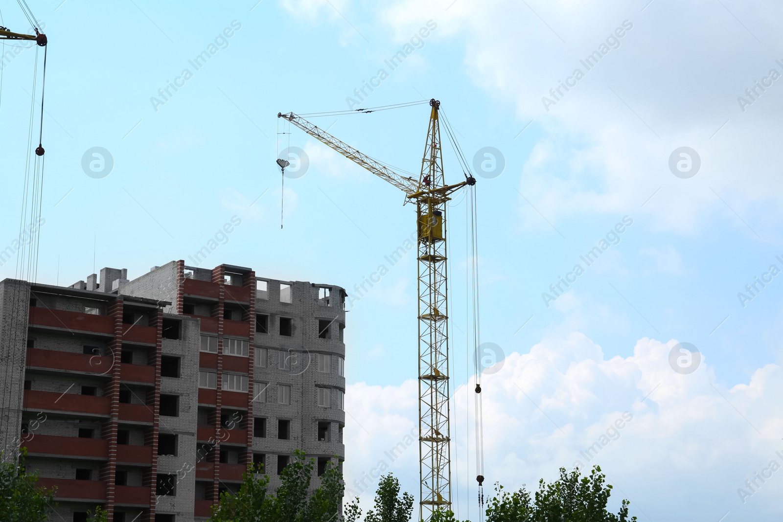 Photo of Construction site with tower crane near unfinished building