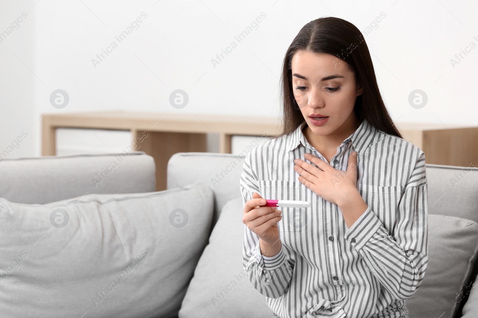 Photo of Young woman with pregnancy test at home. Gynecology and childbirth