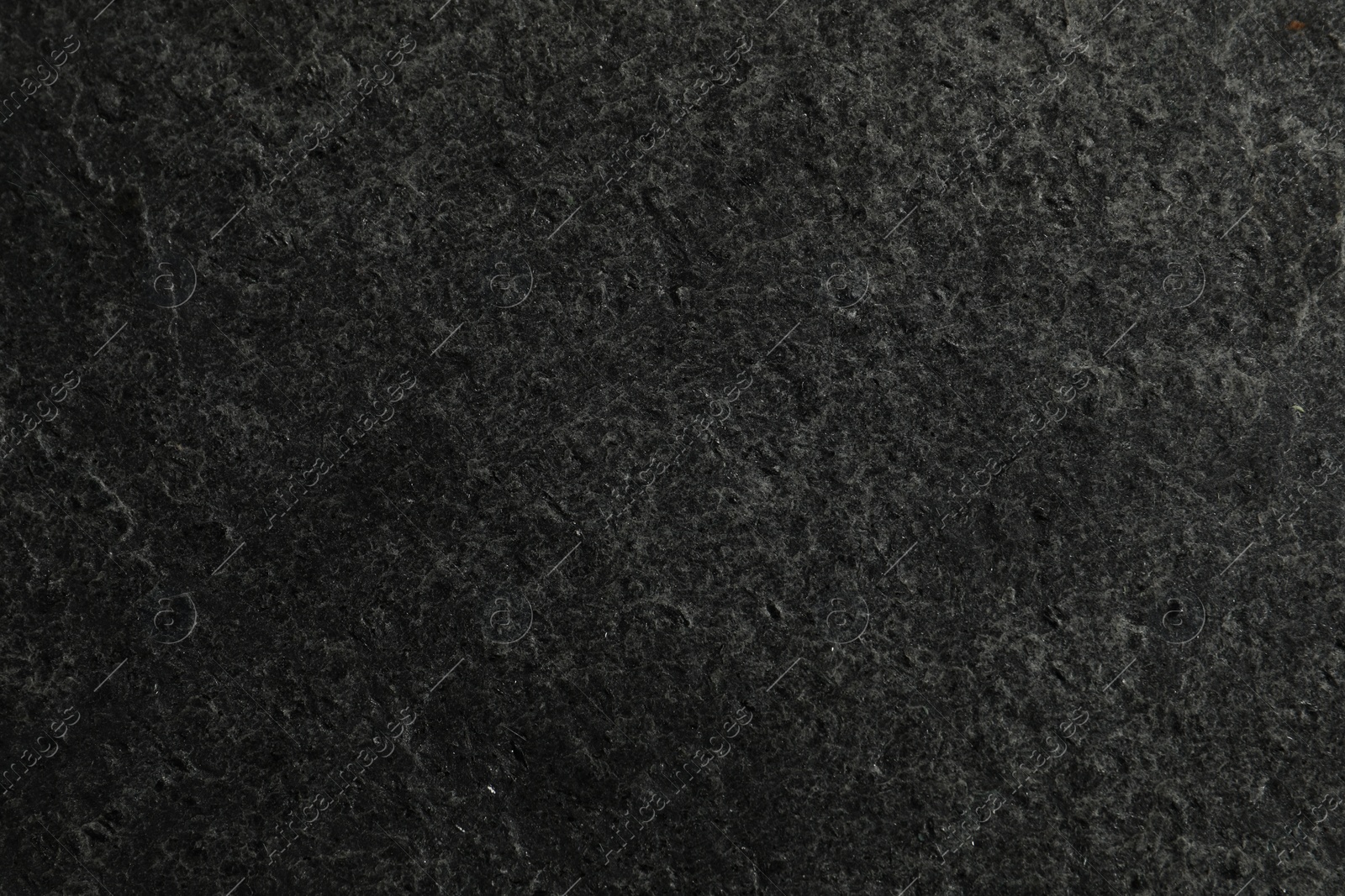 Photo of Texture of dark grey stone surface as background, closeup