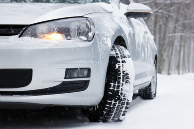Car with winter tires on snowy road outdoors, closeup
