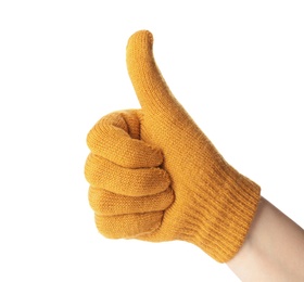 Photo of Woman in yellow woolen glove showing thumb up gesture on white background, closeup. Winter clothes