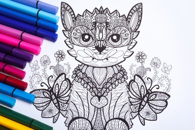 Photo of Felt tip pens on antistress coloring page, top view