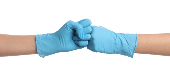 Photo of Doctors in medical gloves making fist bump on white background, closeup
