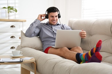 Businessman in shirt and underwear working on laptop at home