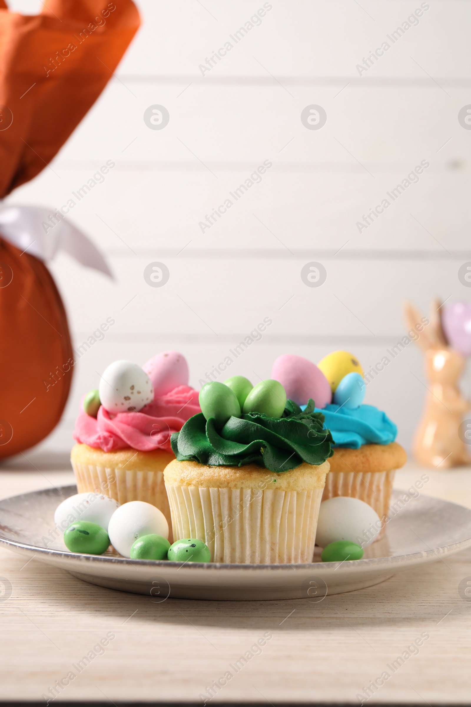 Photo of Tasty cupcakes with Easter decor on wooden table