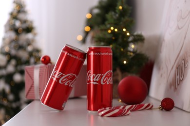 MYKOLAIV, UKRAINE - JANUARY 13, 2021: Cans of Coca-Cola in room decorated for Christmas