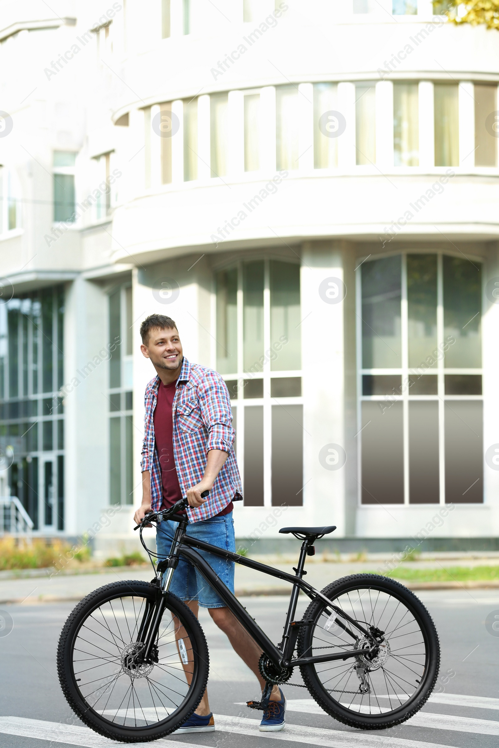 Photo of Handsome man with modern bicycle on city street