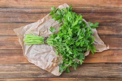 Photo of Fresh green parsley on wooden background, top view