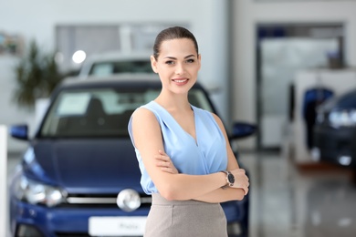 Attractive young saleswoman in car dealership