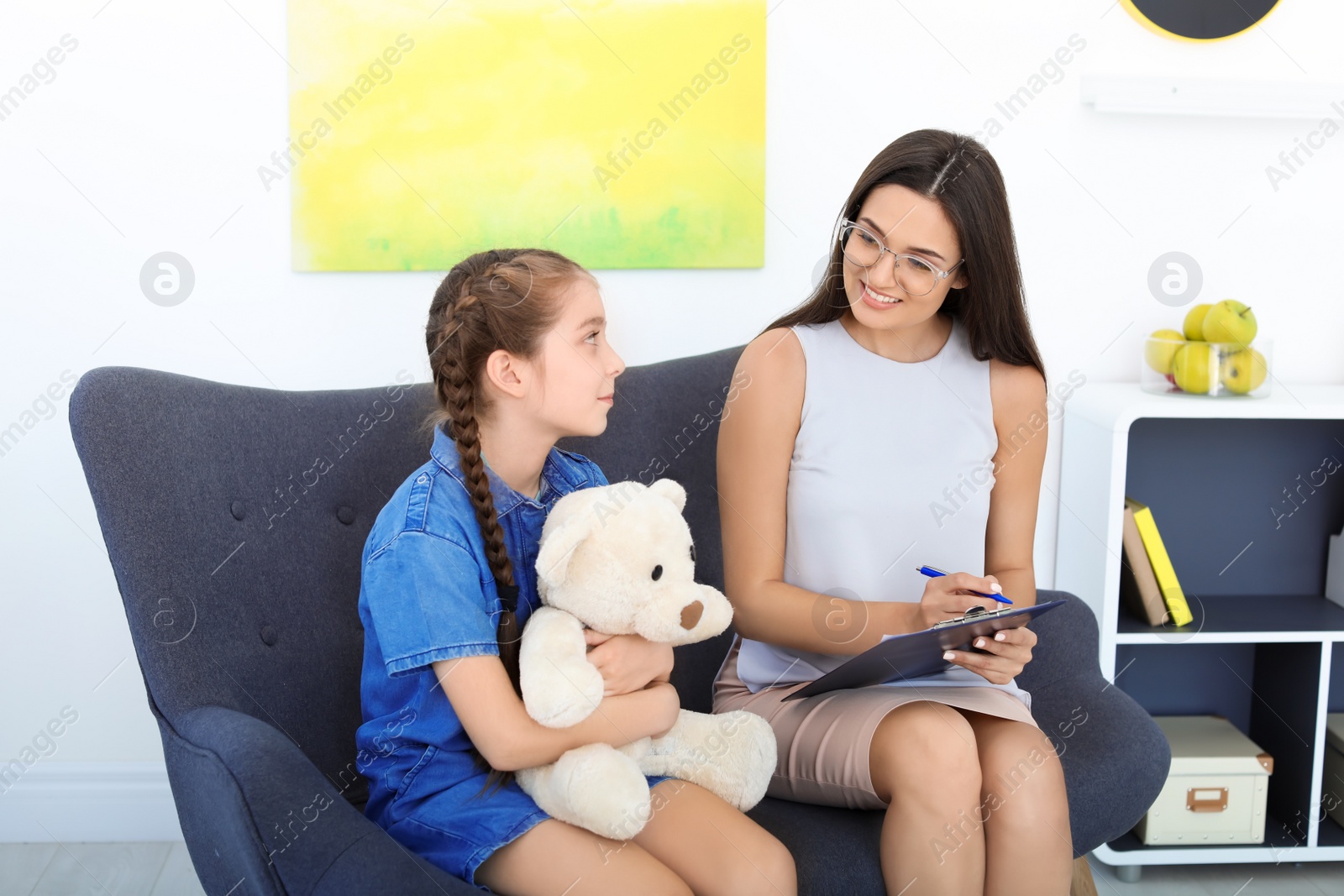 Photo of Child psychologist working with little girl in office