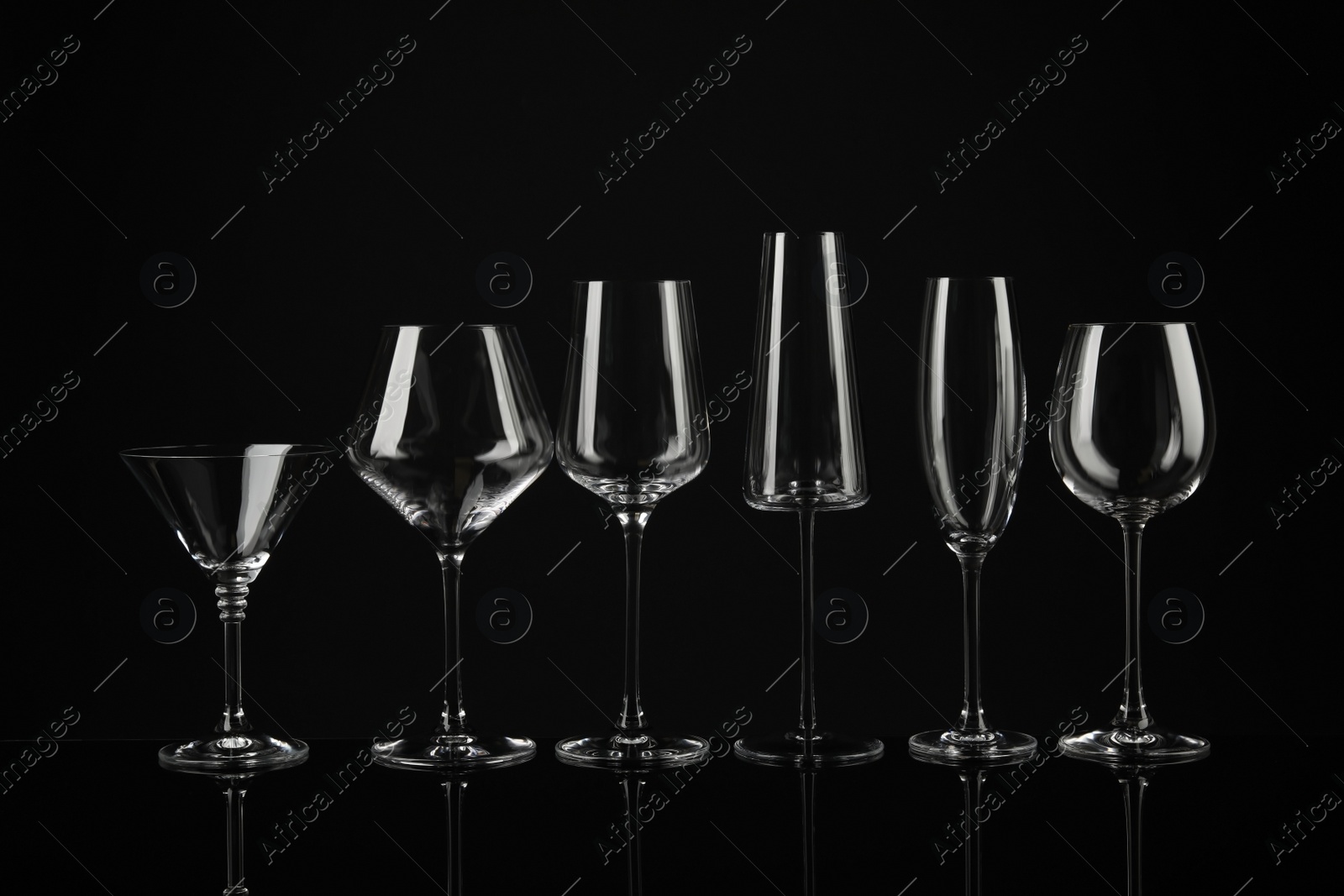 Photo of Set of empty glasses on black background