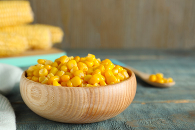 Photo of Tasty canned sweet corn on blue wooden table, closeup