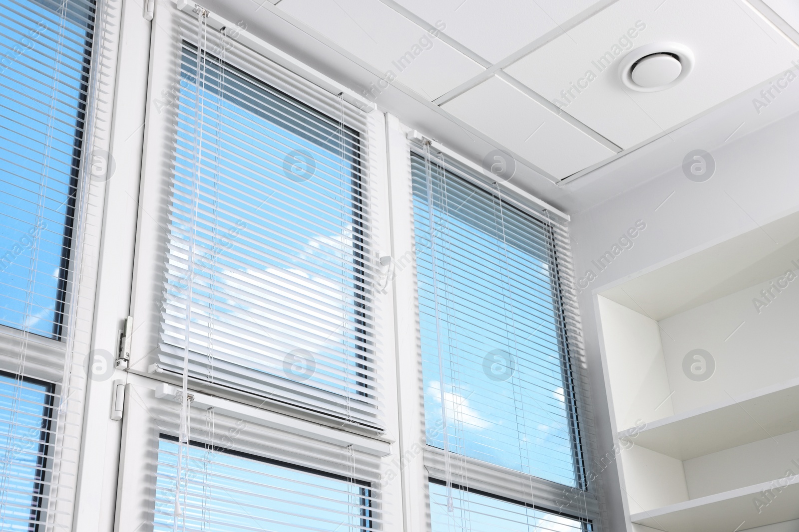 Photo of Large window with horizontal blinds indoors, low angle view