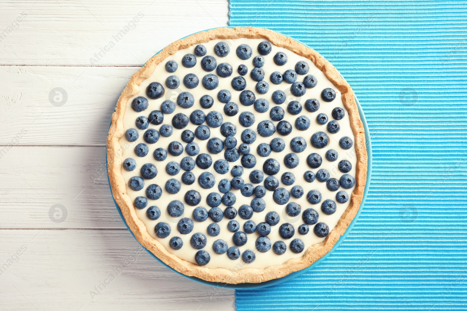 Photo of Tasty cake with blueberry on wooden background, top view