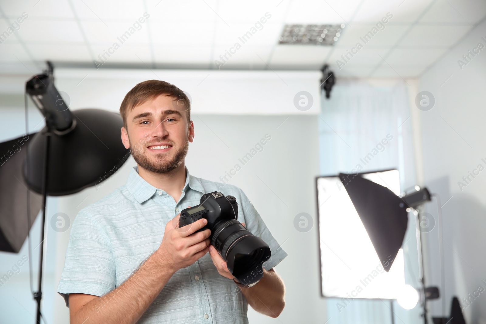 Photo of Professional photographer with camera in photo studio