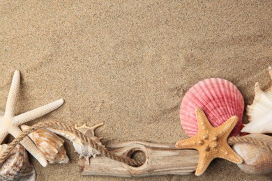 Beautiful starfishes, rope and sea shells on sand, flat lay. Space for text