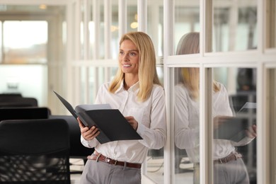 Photo of Smiling woman with folder in office. Lawyer, businesswoman, accountant or manager