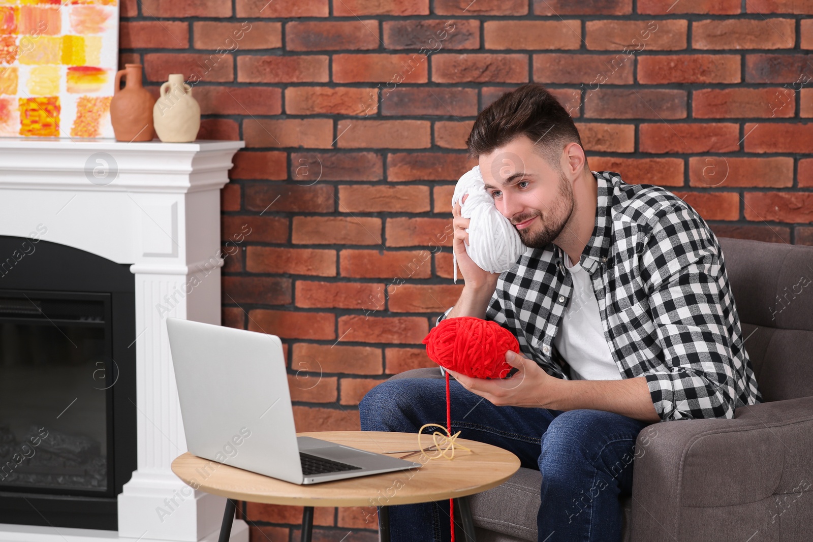 Photo of Man learning to knit with online course at home. Time for hobby