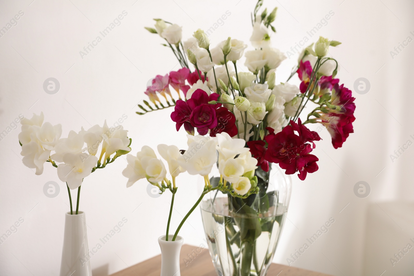 Photo of Beautiful spring freesia flowers in light room, closeup