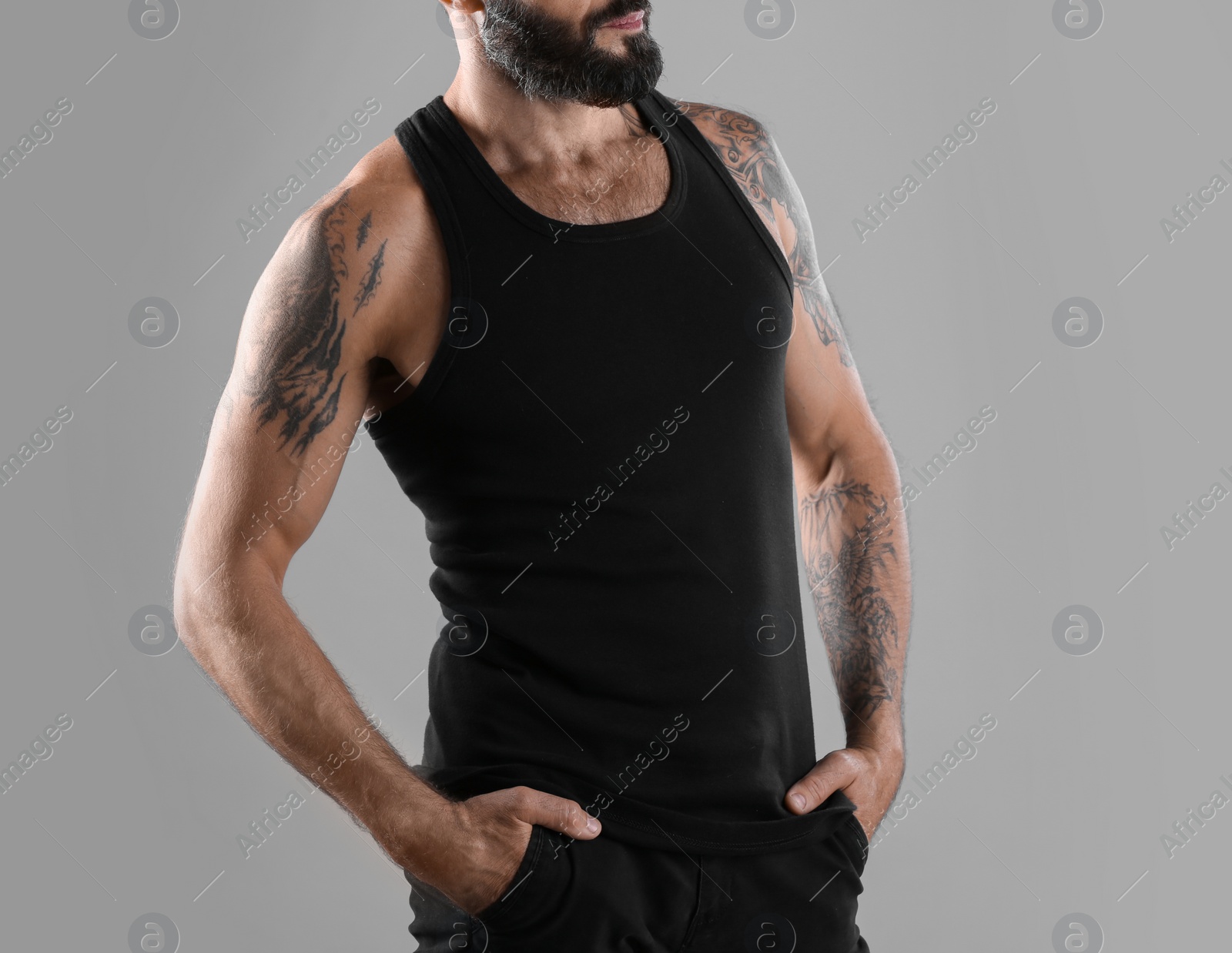 Photo of Tattooed man on grey background, closeup view