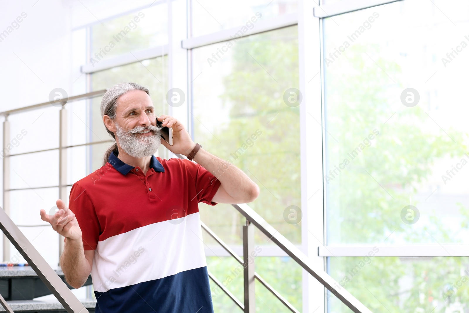 Photo of Handsome mature man with mobile phone, indoors